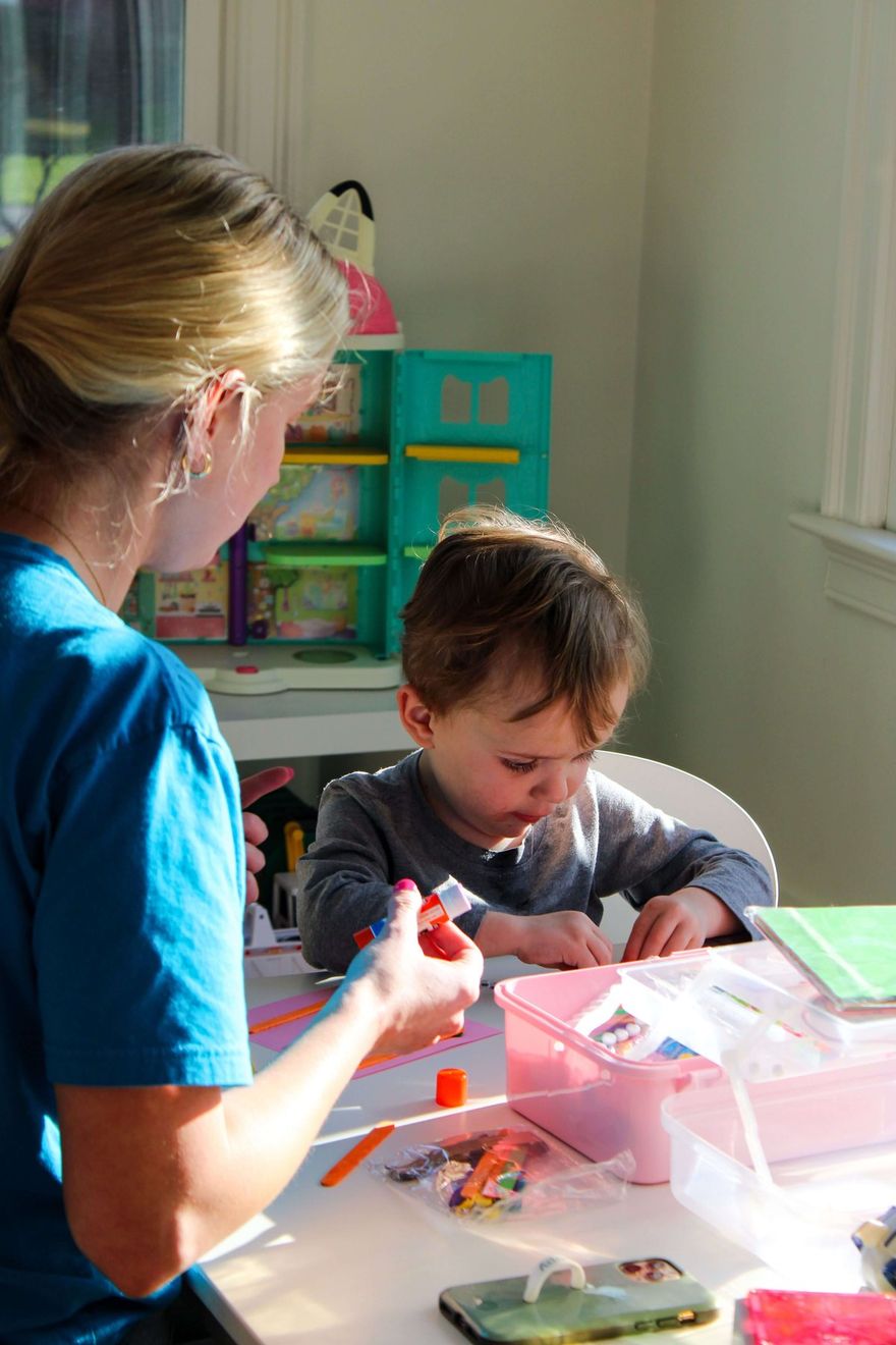 Técnica de conducta trabaja con un niño pequeño en una mesa en un cuarto de juegos soleado
