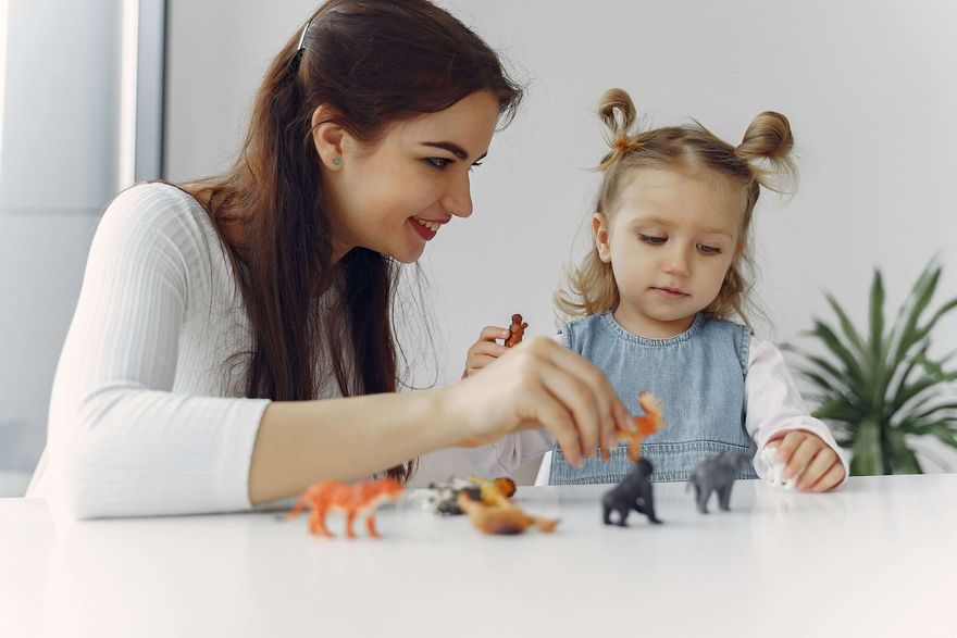 Técnica de conducta trabaja con un niño pequeño en una mesa en un cuarto de juegos soleado