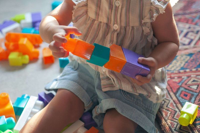 Niño pequeño apilando bloques de colores durante terapia ABA lúdica en casa